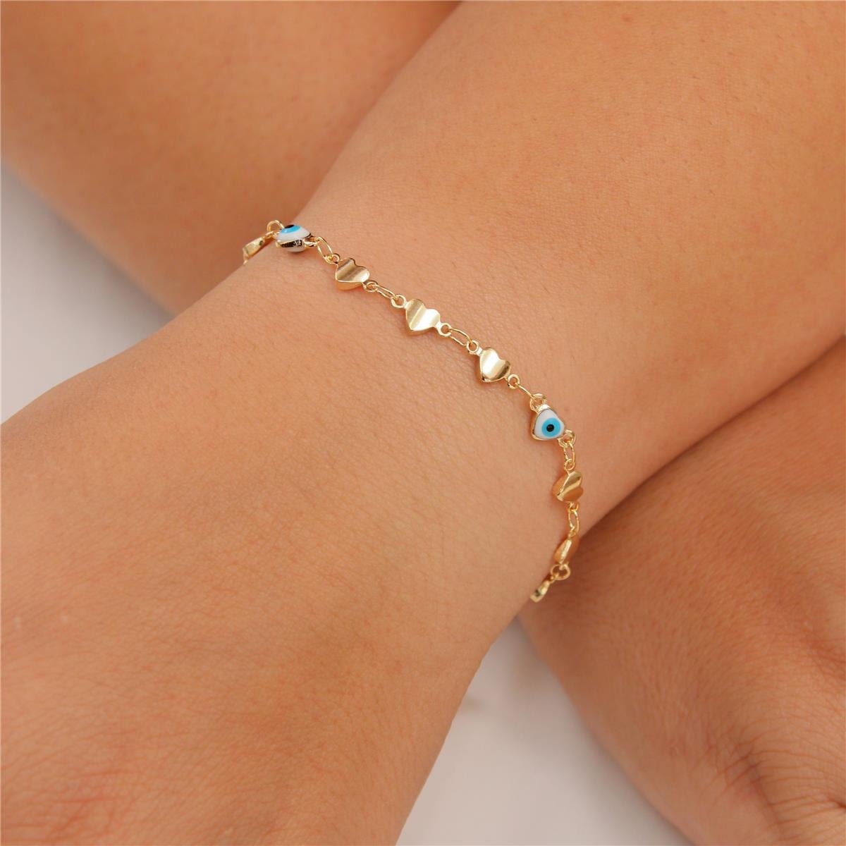 PULSEIRA FOLHEADO A OURO CORAÇÕES E OLHO GREGO
